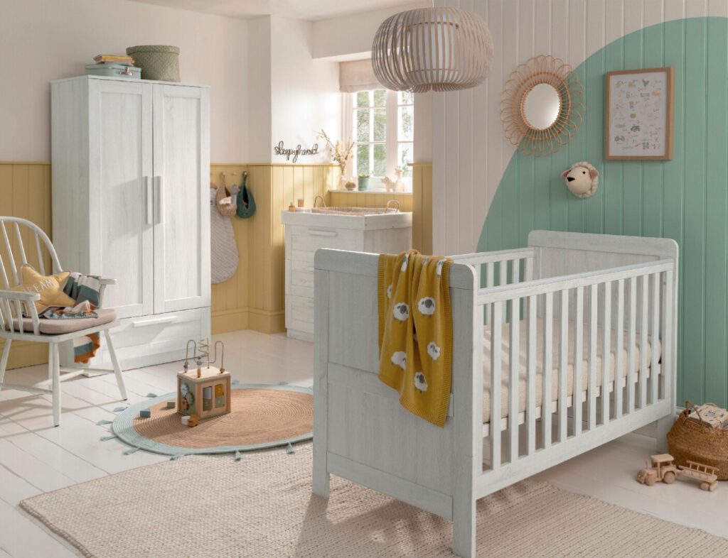 baby nursery white cot with yellow and green decorations